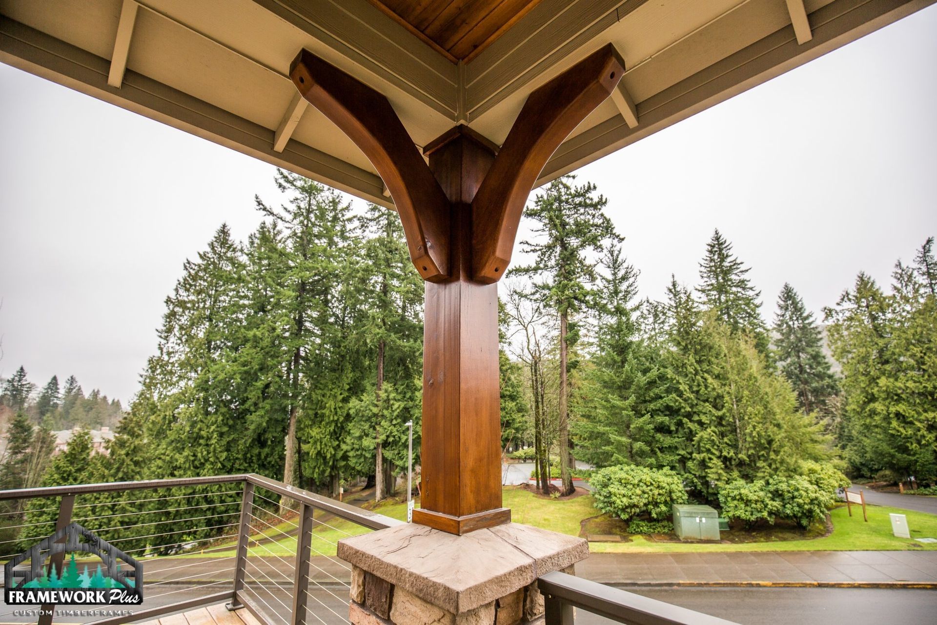 A balcony with a wooden post and trees in the background