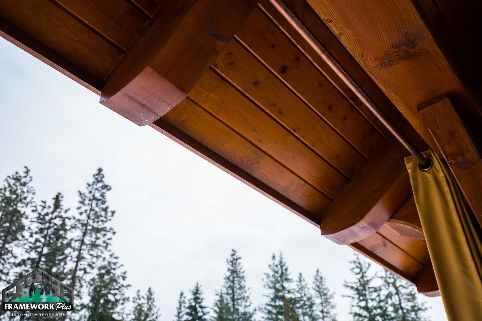 A wooden ceiling of a house with trees in the background