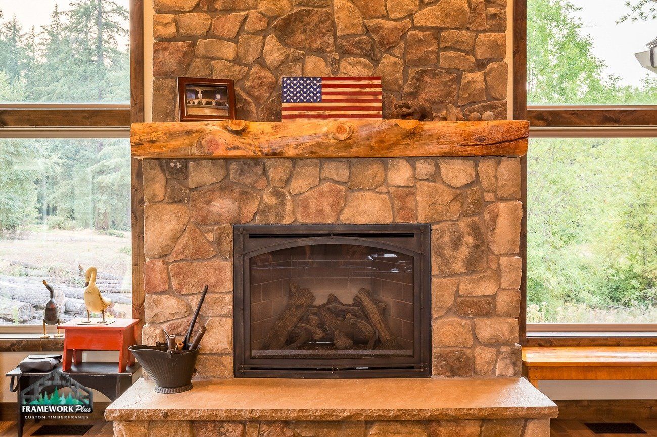 A fireplace in a living room with an american flag on the mantle.