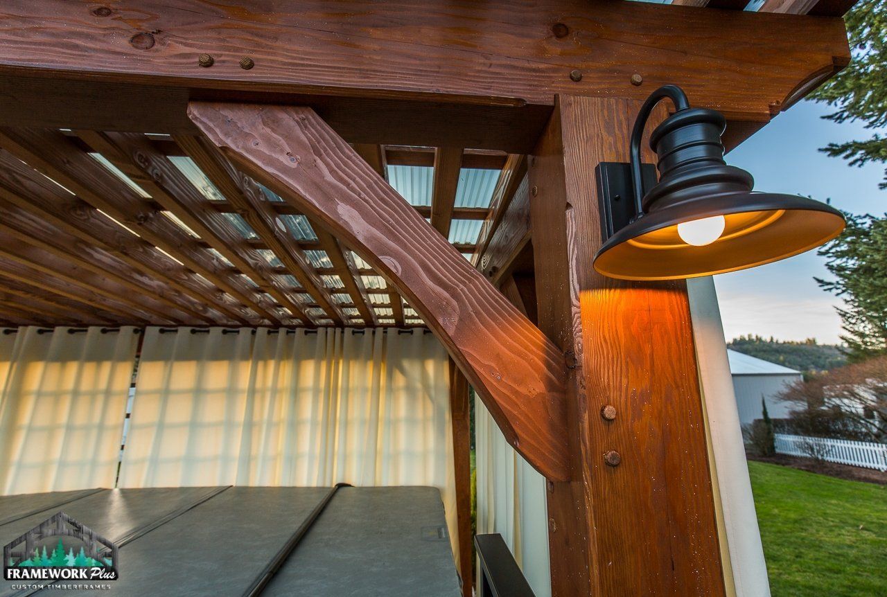 A wooden pergola with a light on the side of it.