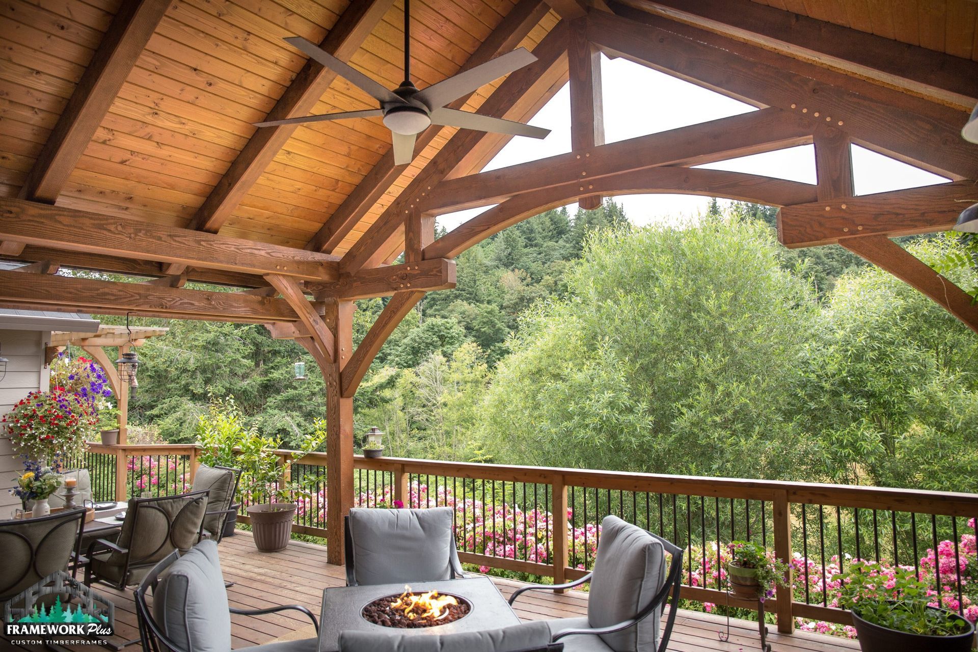 A wooden deck with a fire pit and a ceiling fan.