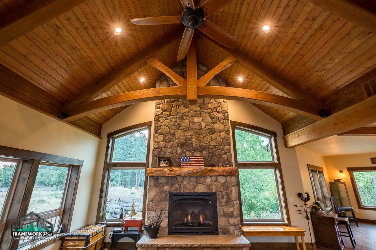 A living room with a fireplace and a ceiling fan.