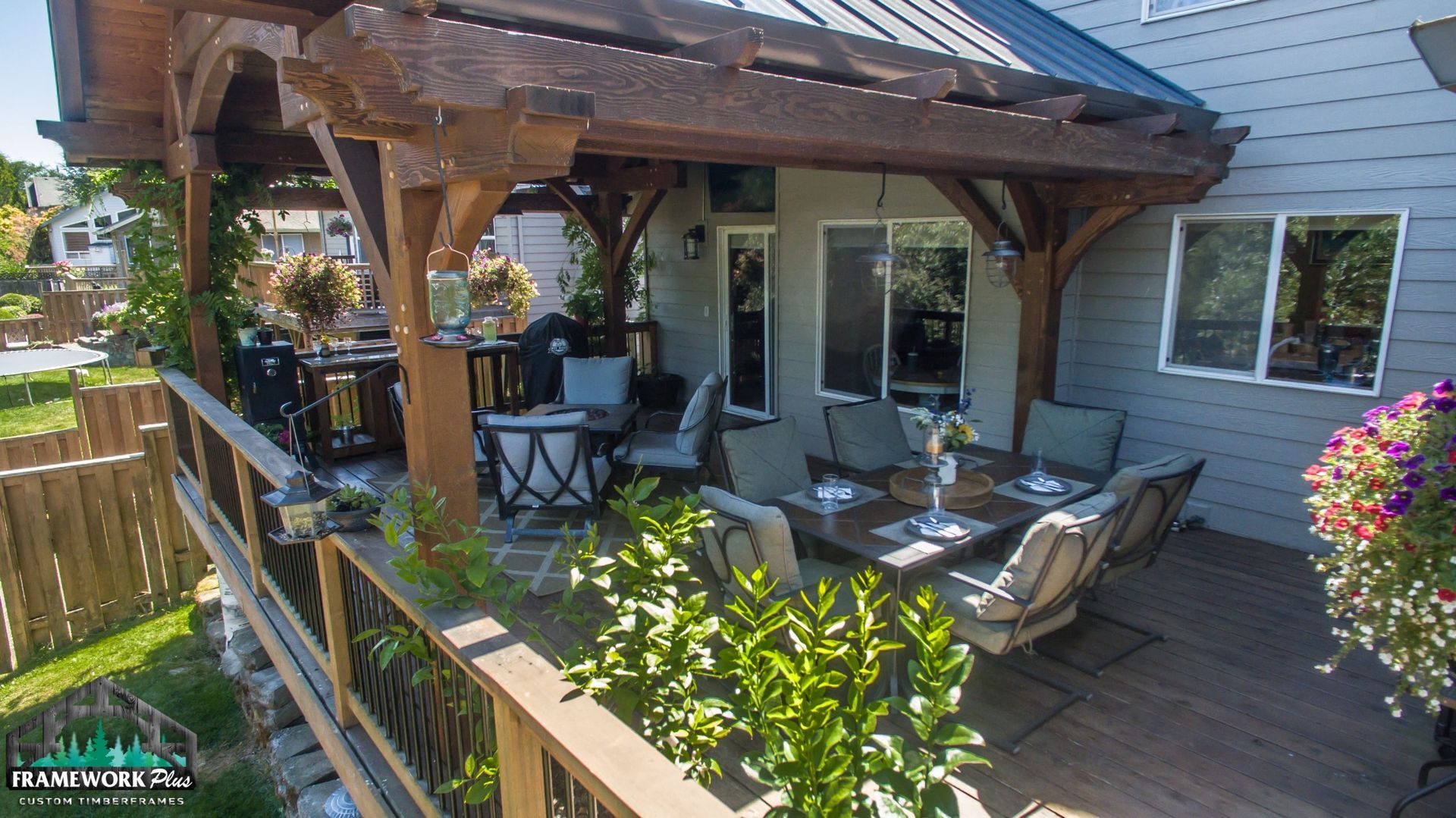 A wooden deck with a pergola and a table and chairs on it.