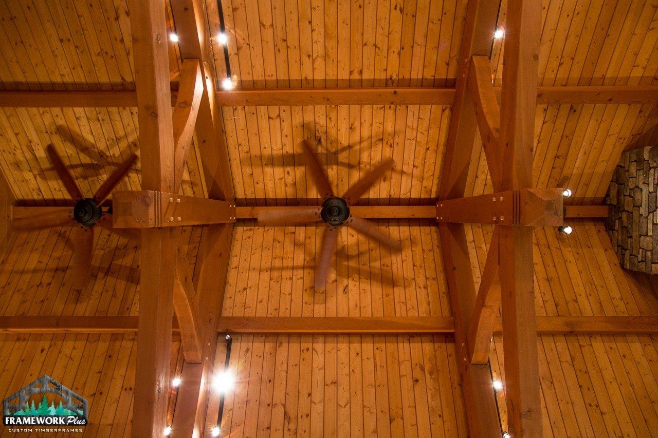 A ceiling fan is hanging from the ceiling of a wooden building.