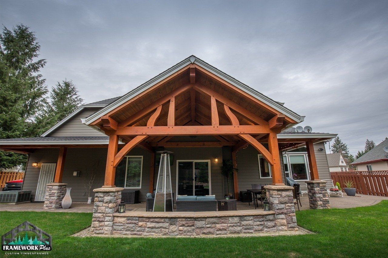 A house with a wooden porch and a stone wall