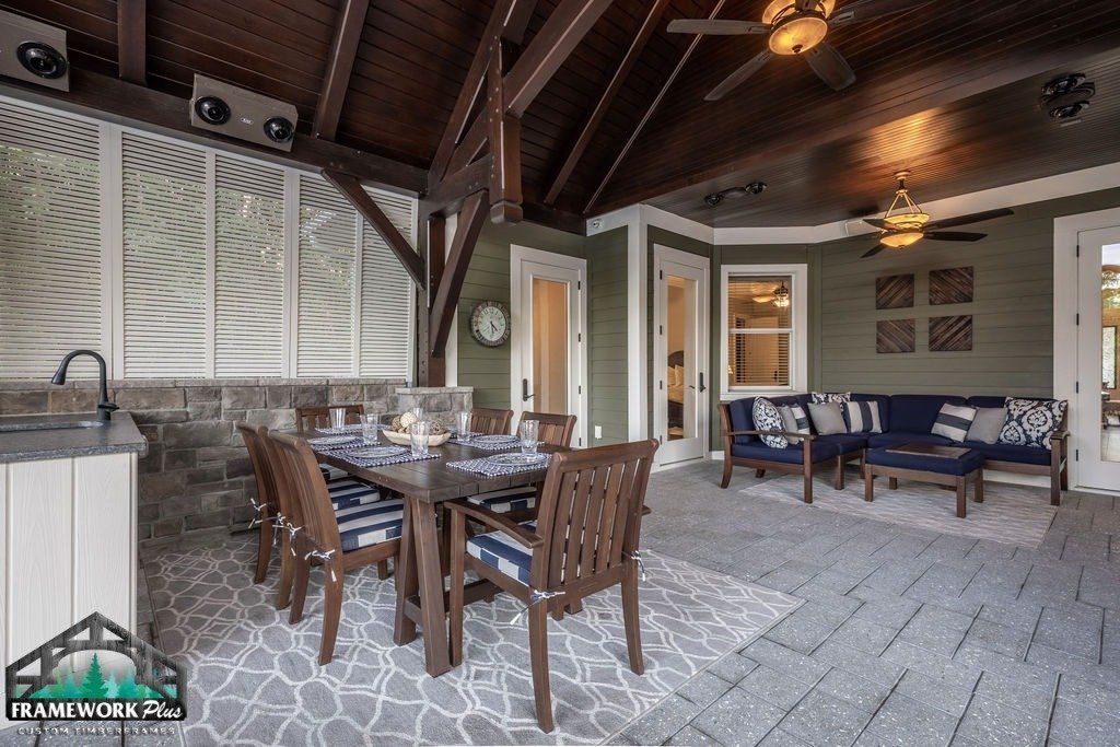 A patio with a table and chairs and a ceiling fan.