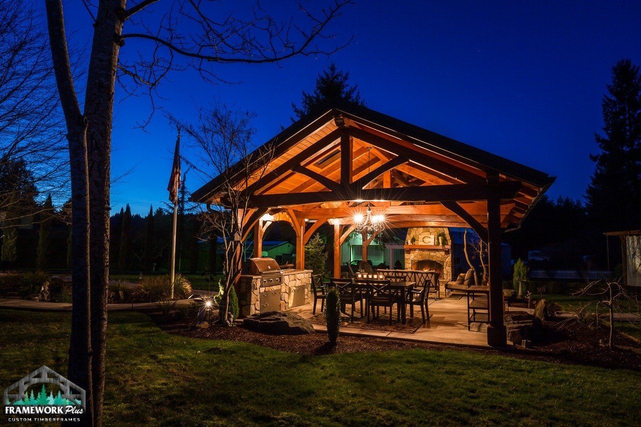 A large wooden pavilion is lit up at night.
