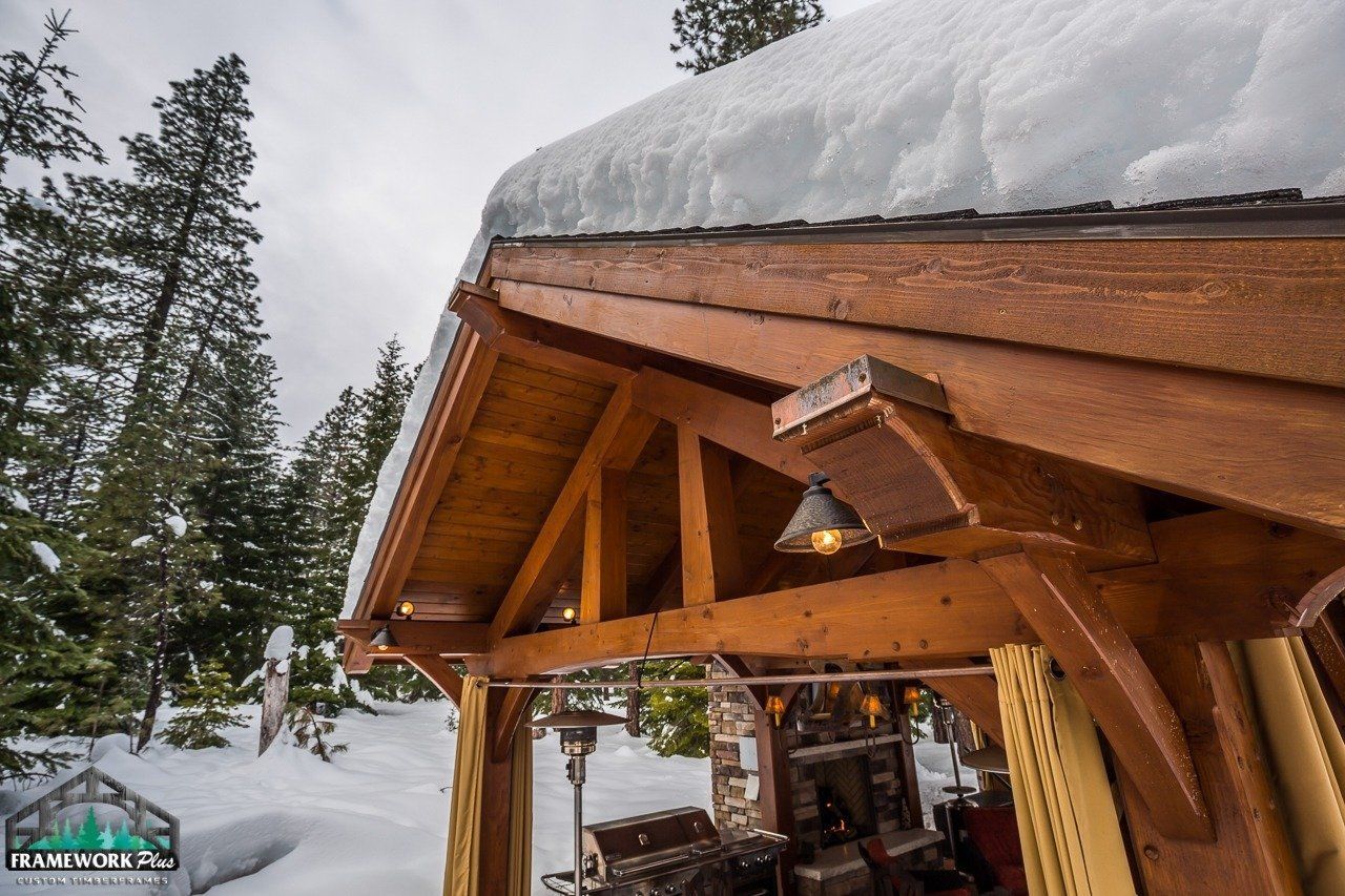 The roof of a wooden structure is covered in snow.
