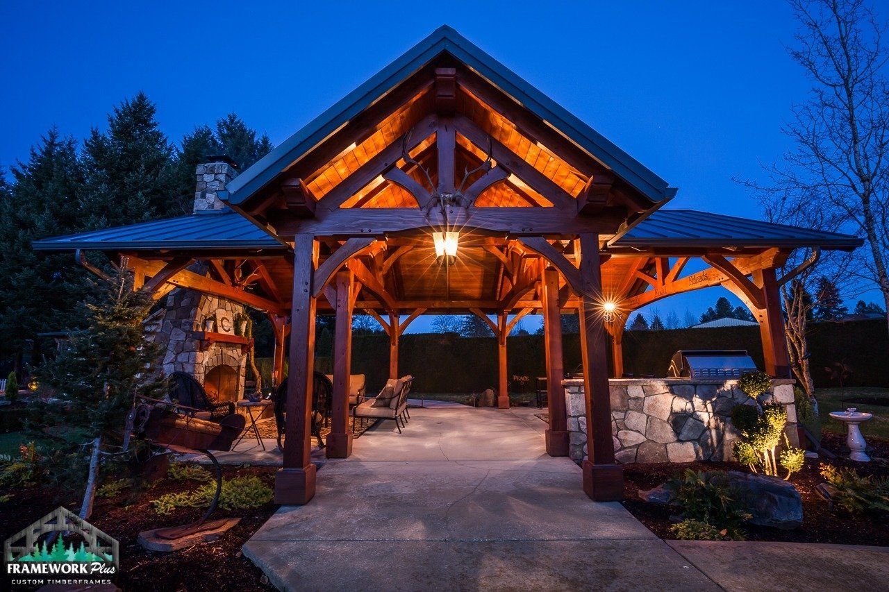 A large wooden pavilion is lit up at night.
