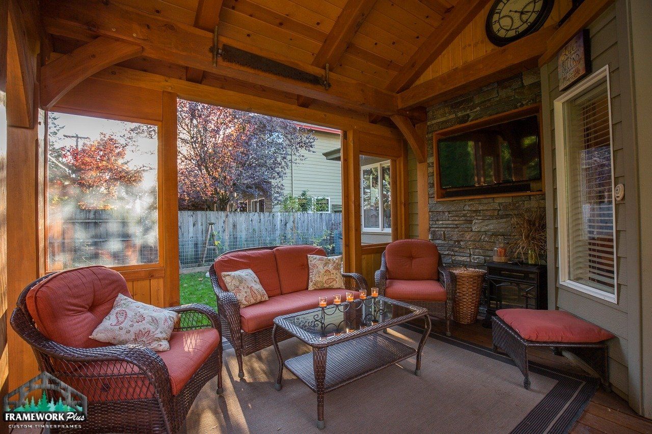 A living room with a couch , chairs , table and television.
