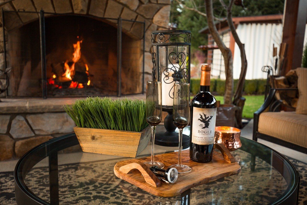 A bottle of wine is sitting on a table in front of a fireplace.