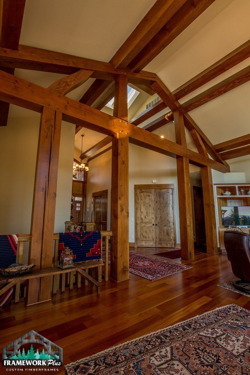 A living room with wooden beams and a rug
