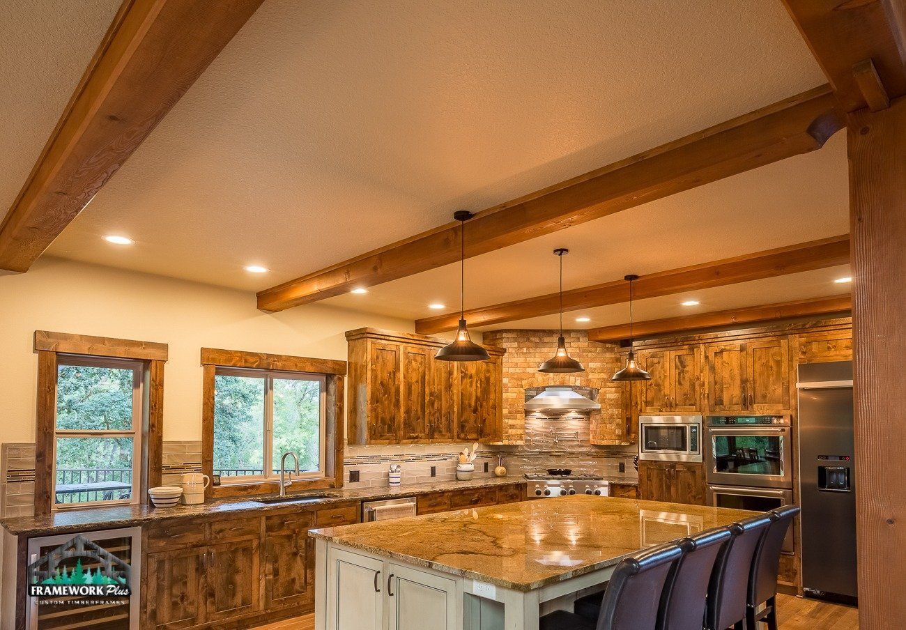 A kitchen with wooden cabinets , granite counter tops , stainless steel appliances , and a large island.