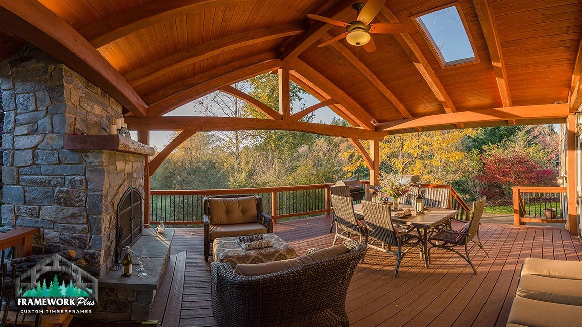 A wooden deck with a ceiling fan and a fireplace