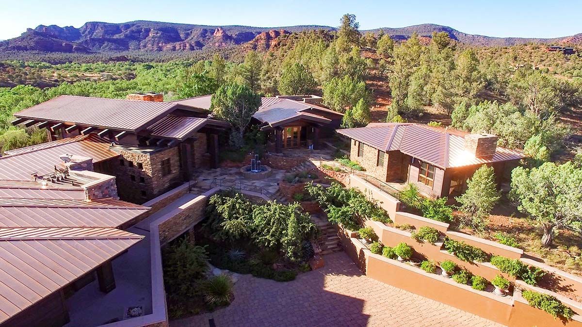 Luxury home nestled in a desert landscape with red rock formations.
