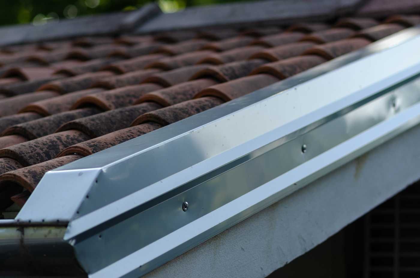 Metal flashing installed along the edge of a clay tile roof.