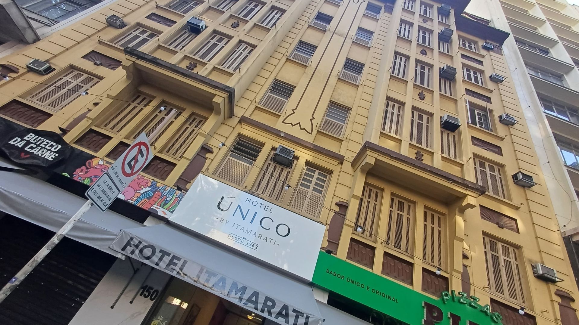 Um prédio grande com muitas janelas e uma placa que diz hotel.