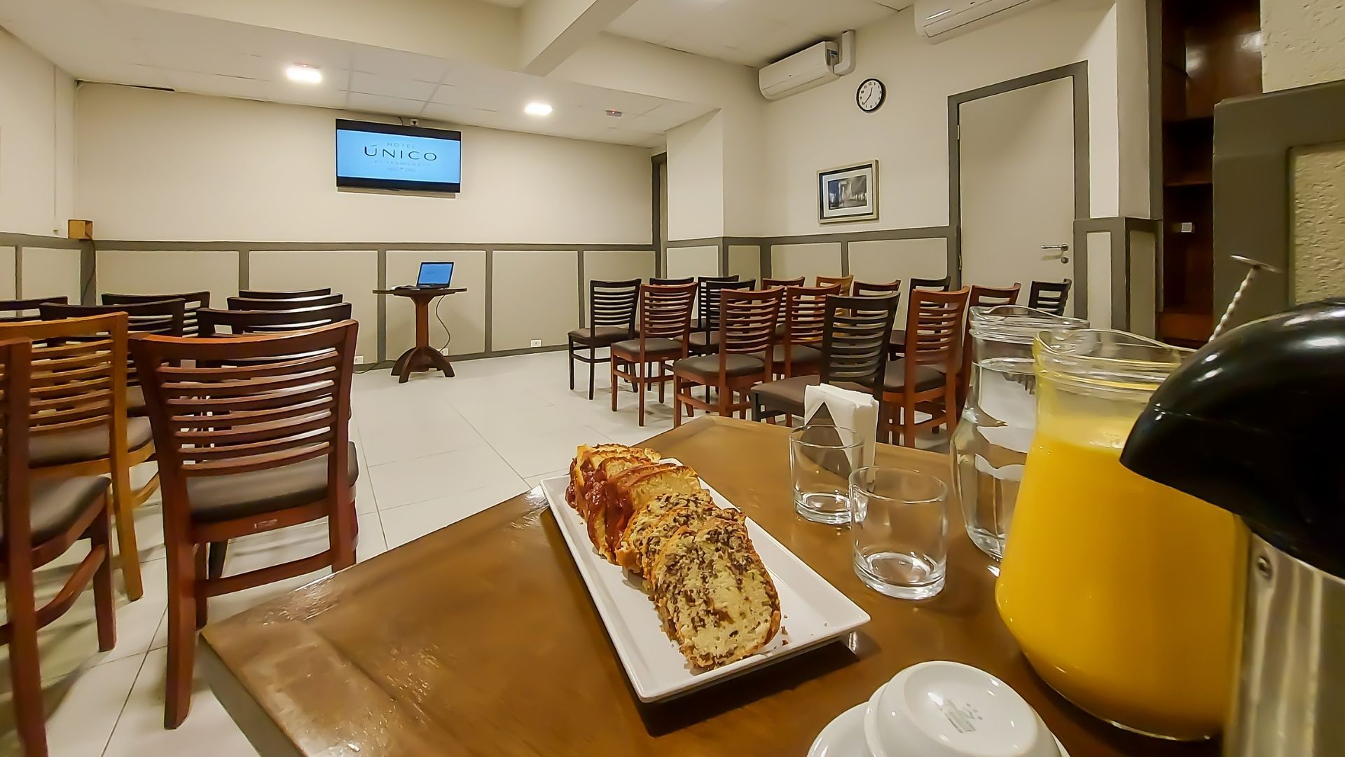 Uma mesa com um pão e uma jarra de suco de laranja.