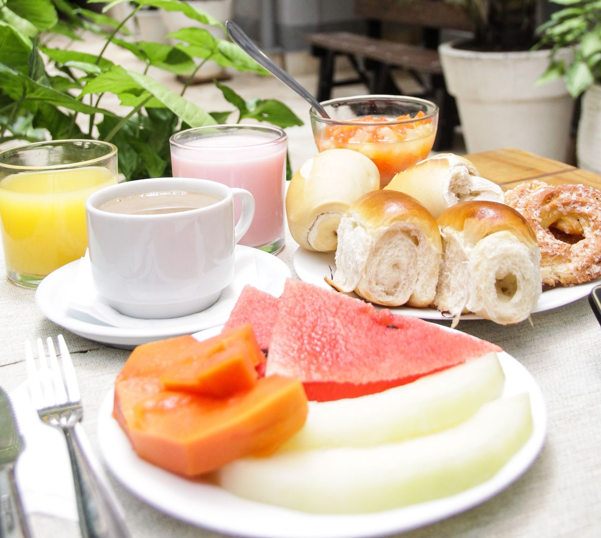 Uma mesa coberta com pratos de comida e uma xícara de café