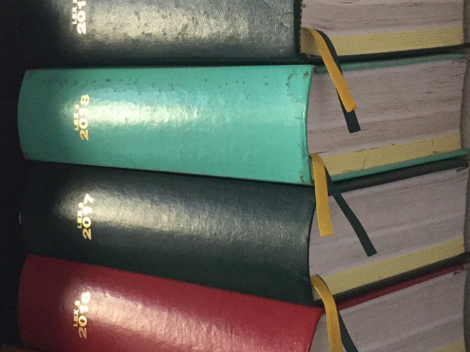 Libri impilati verticalmente, con il dorso rivolto verso l'osservatore. Sono visibili gli anni 2018, 2016, 2017 e 2015. Ogni libro ha un segnalibro giallo.