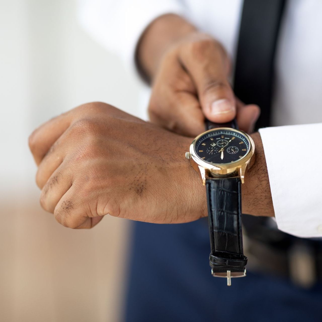 a man is looking at his watch which shows the time as 10:10