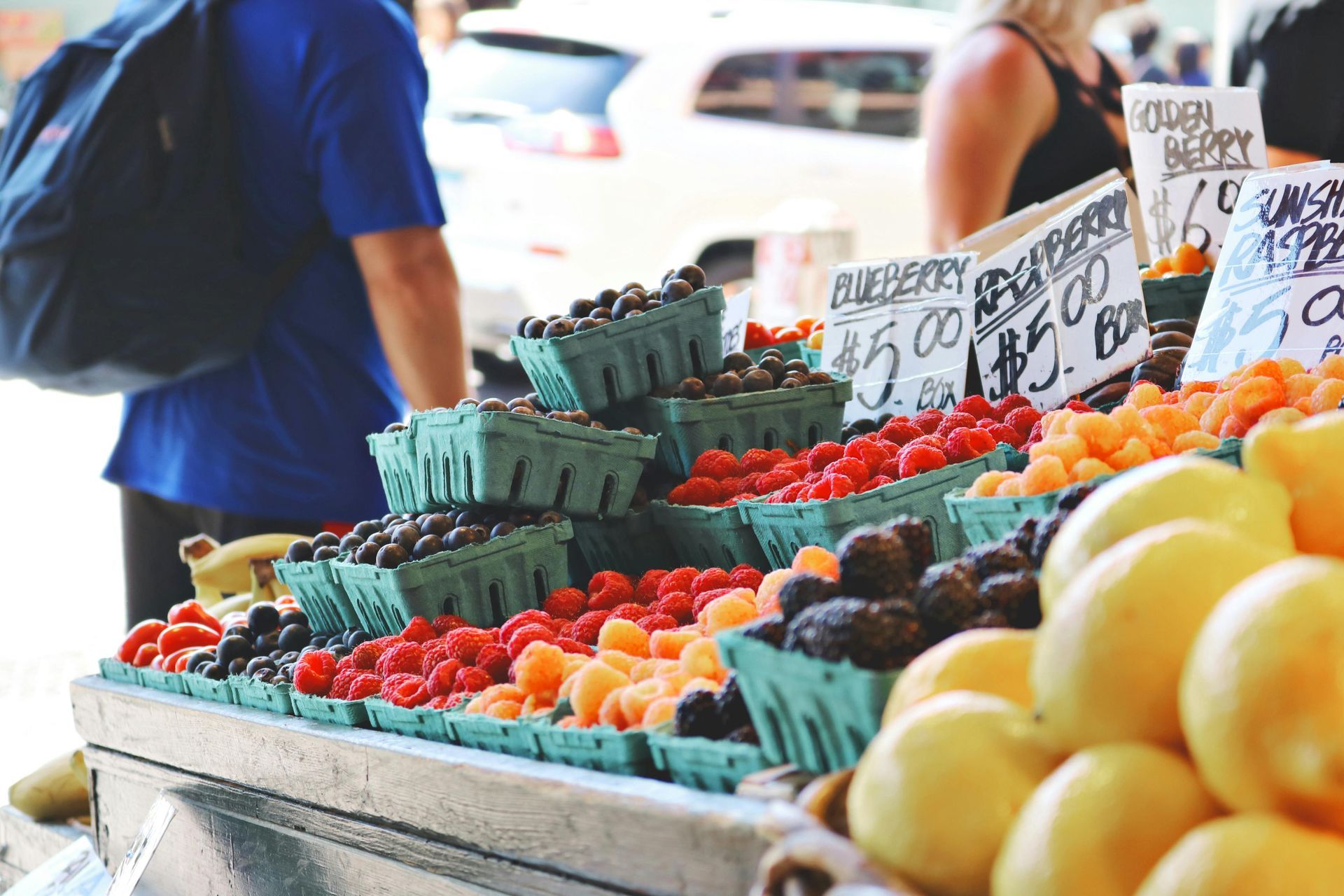 A fruit stand with a sign that says strawberry on it