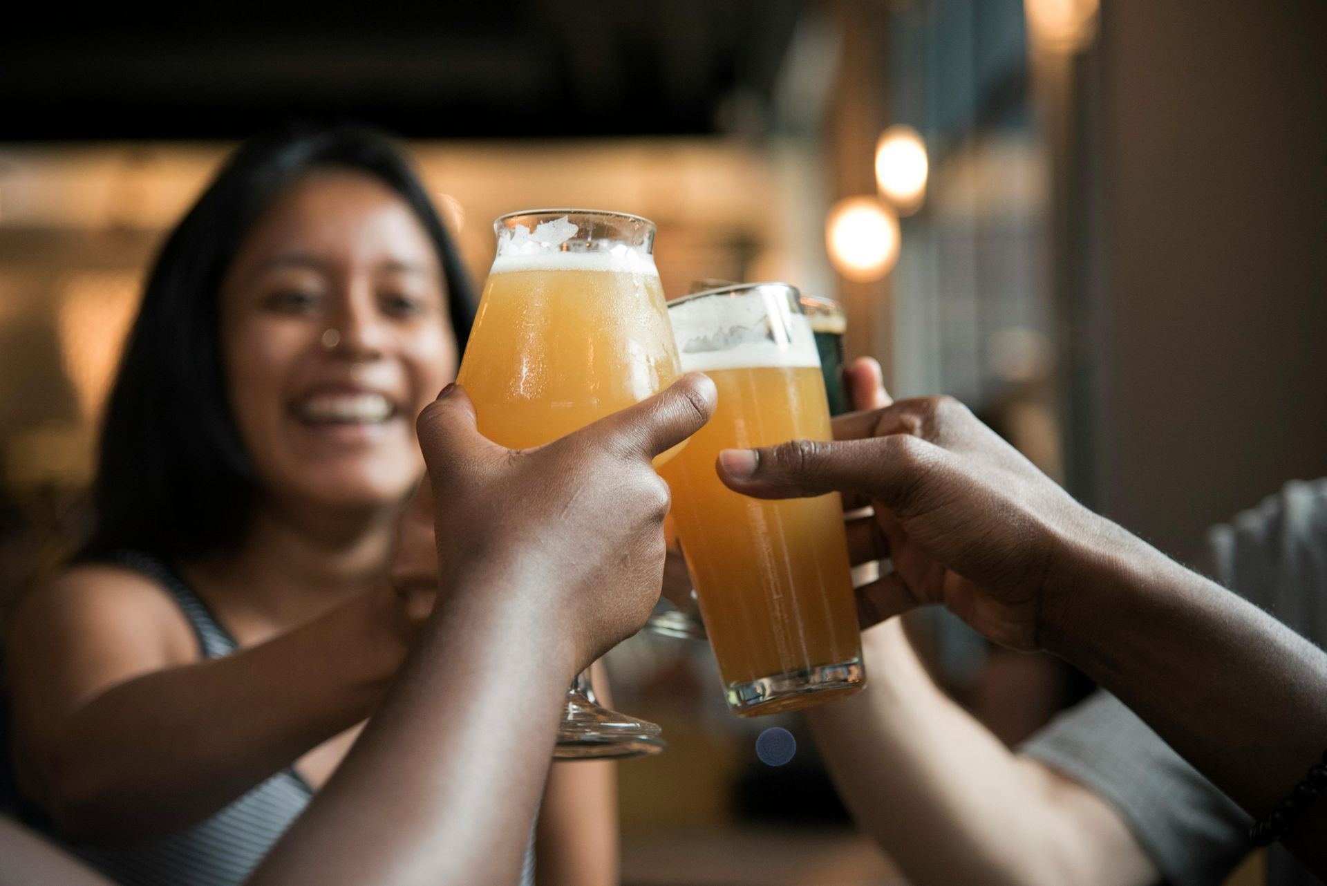 A group of people are toasting with glasses of beer.