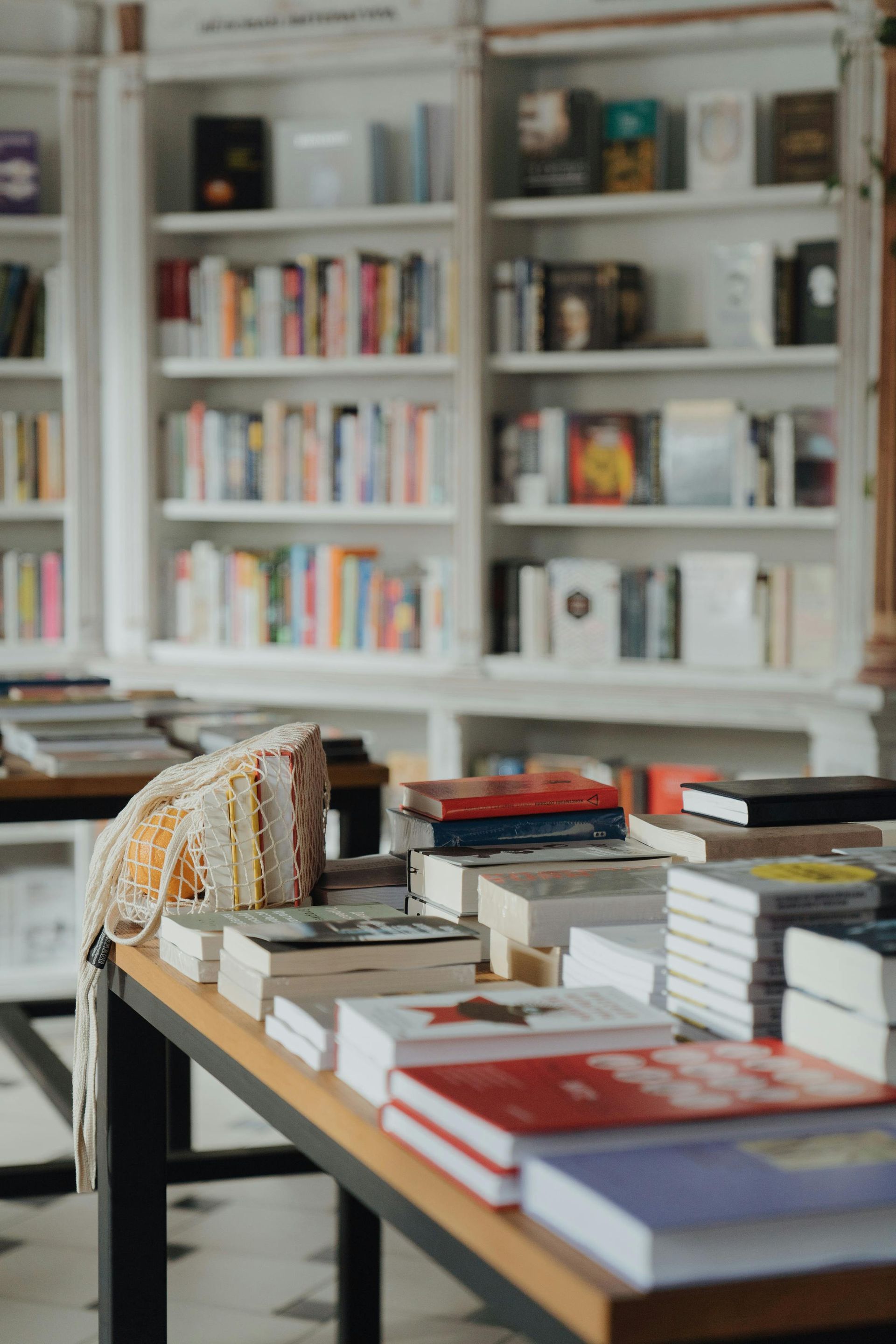 A bookstore filled with lots of books on tables and shelves.