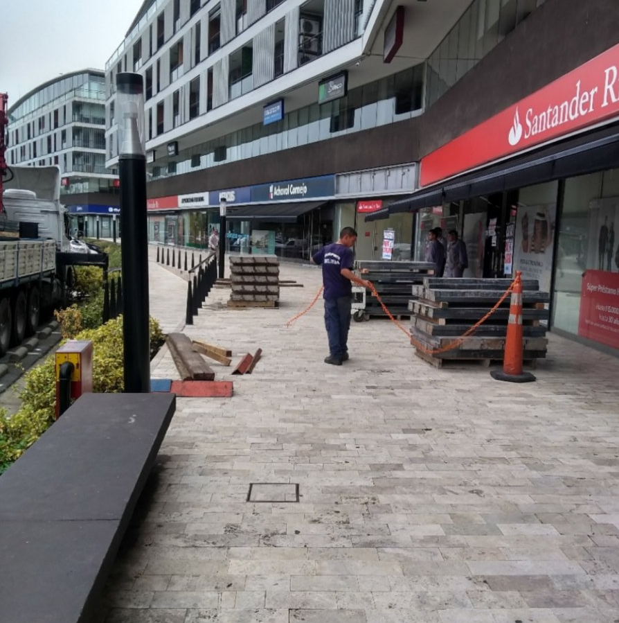 Un hombre está parado frente a un banco Santander.
