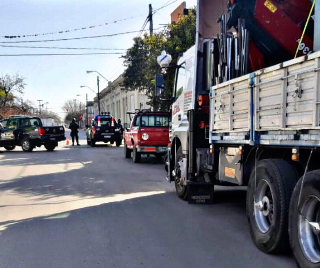 Un camión rojo está estacionado al costado de la carretera al lado de un camión blanco.