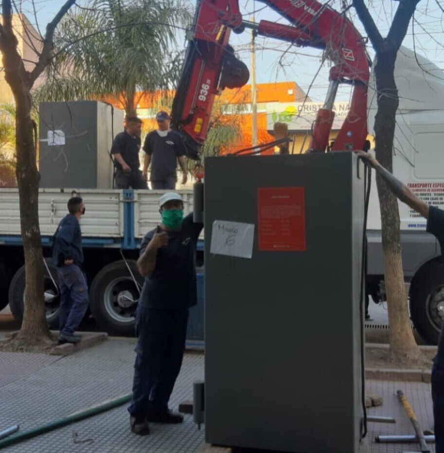 Un hombre con una máscara está parado frente a una grúa que dice