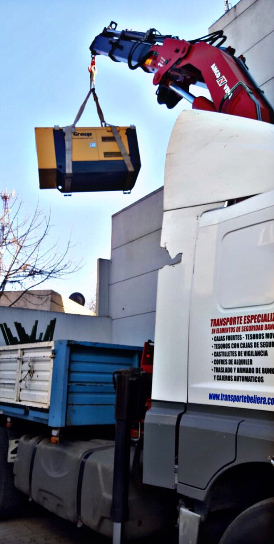 Una grúa está levantando un contenedor desde la parte trasera de un camión.