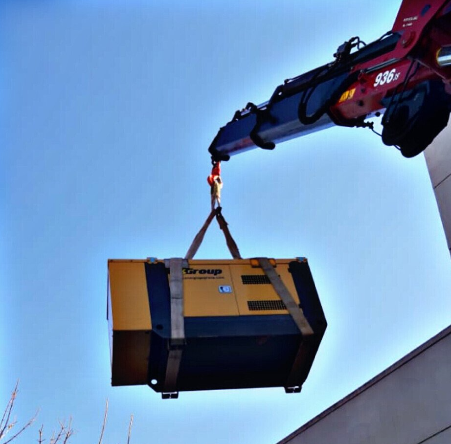 Una caja de grupo está siendo levantada por una grúa