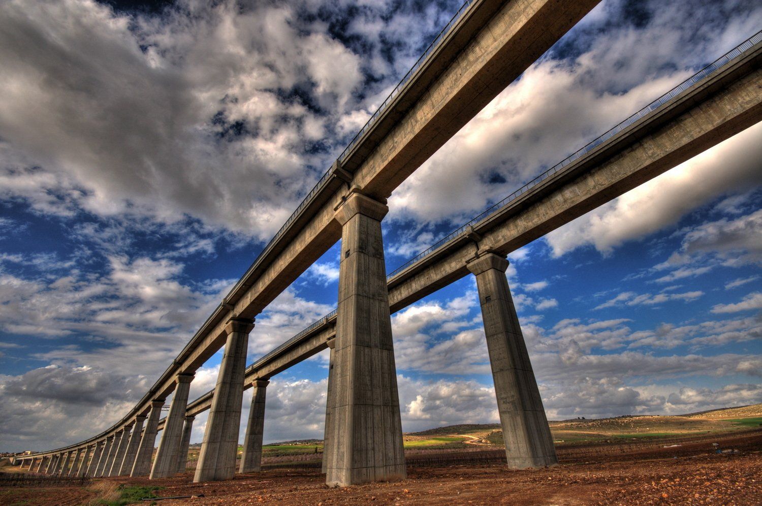 גשר בטון לכביש מהיר על רקע שמיים כחולים עם עננים.
