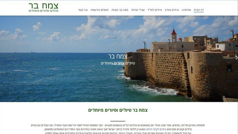 נוף פנורמי של עכו, ישראל, עם ים טורקיז, מבצר אבן ומבנים תחת שמיים כחולים.