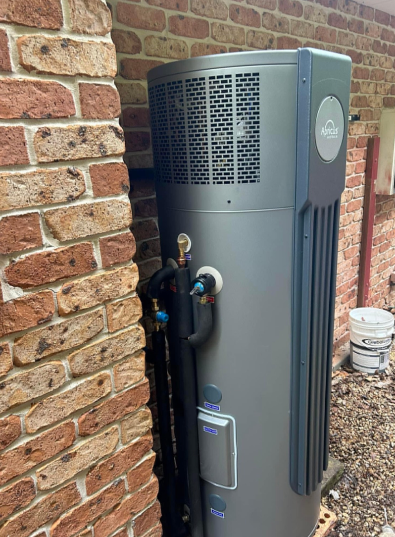 Person Draining Water Heater With a Hose in a Utility Room With Insulation — B & A Plumbing & Gas In Wauchope, NSW
