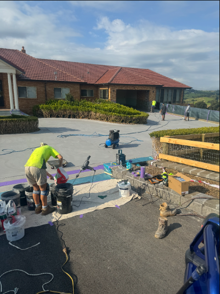 A Hose Is Connected to A Brick Wall Next to A Fence — Illawarra Resurfacing Pty Ltd in Balgownie, NSW