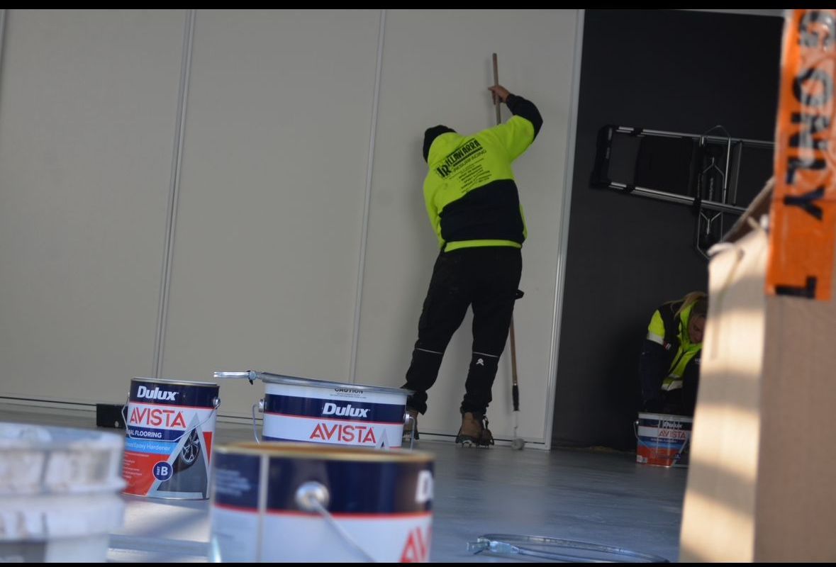 A Worker Applying Epoxy Flooring in a House — Illawarra Resurfacing Pty Ltd in Balgownie, NSW