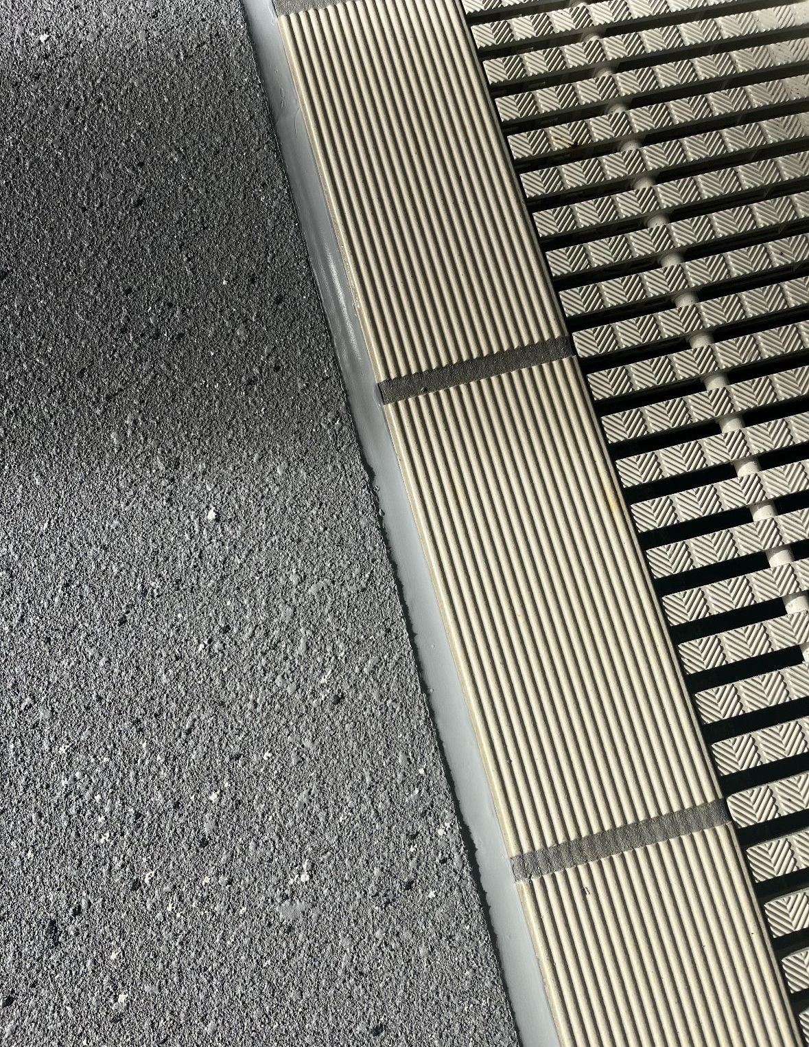 A Hose Is Laying on The Sidewalk Next to A Brick Building — Illawarra Resurfacing Pty Ltd in Fairy Meadow, NSW