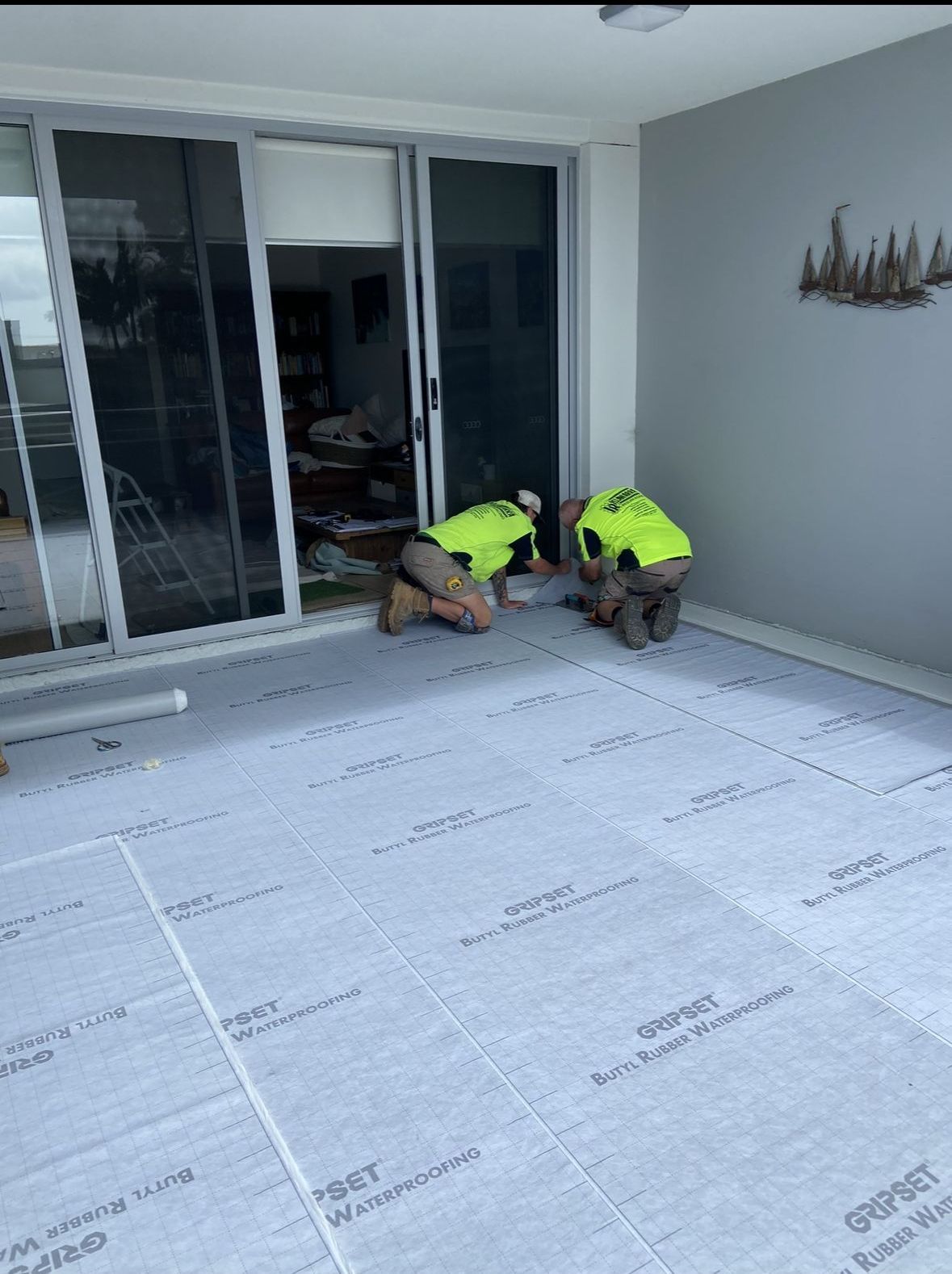 Two Workers Setting up Waterproofing In Front of The Doors — Illawarra Resurfacing Pty Ltd in Balgownie, NSW