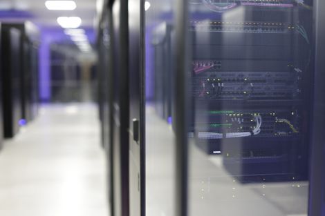 A hallway filled with servers in a data center.