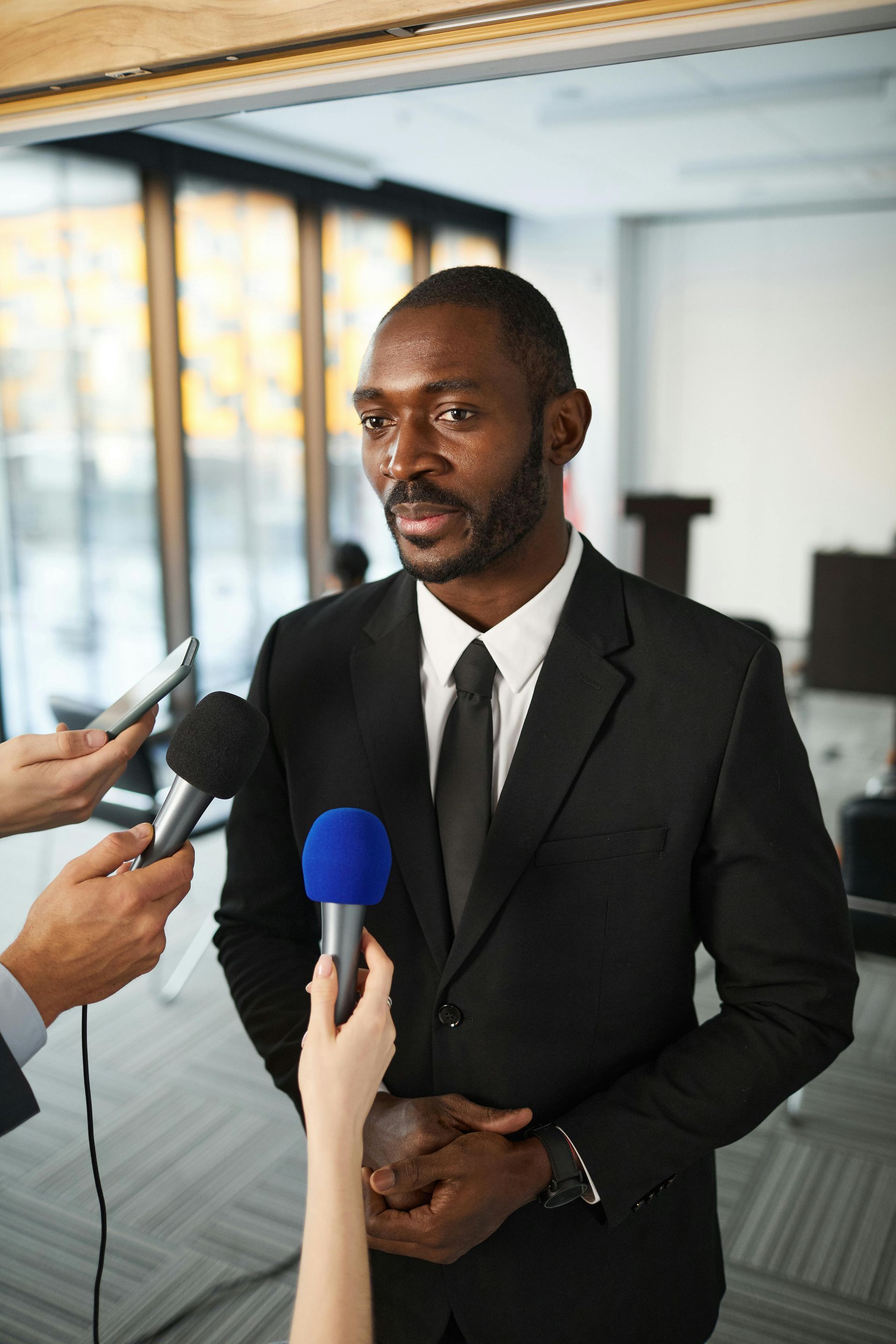 A man in a suit is being interviewed by the TV media