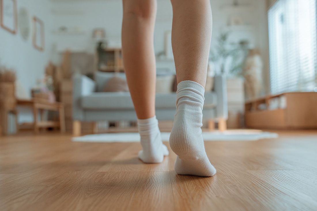 A Woman Wearing White Socks is Walking on a Wooden Floor — Floor Zone Gympie In Rainbow Beach, QLD