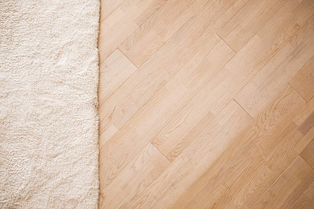 A Close Up of a Wooden Floor Next to a White Rug — Floor Zone Gympie In Gympie, QLD