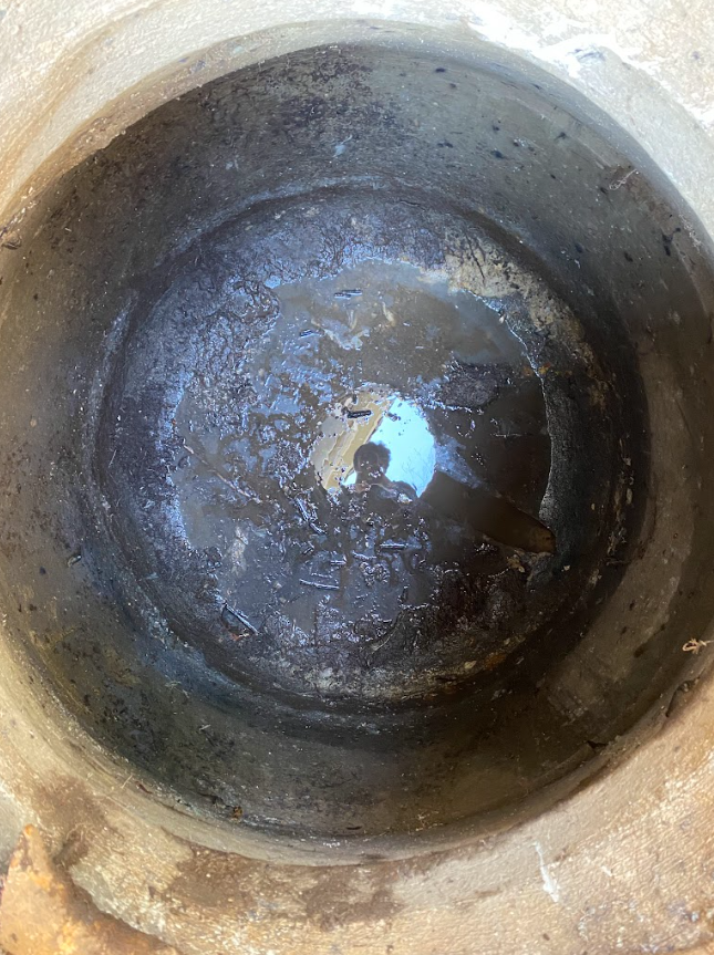 Close-up of a rusty, dark drain ready for cleaning