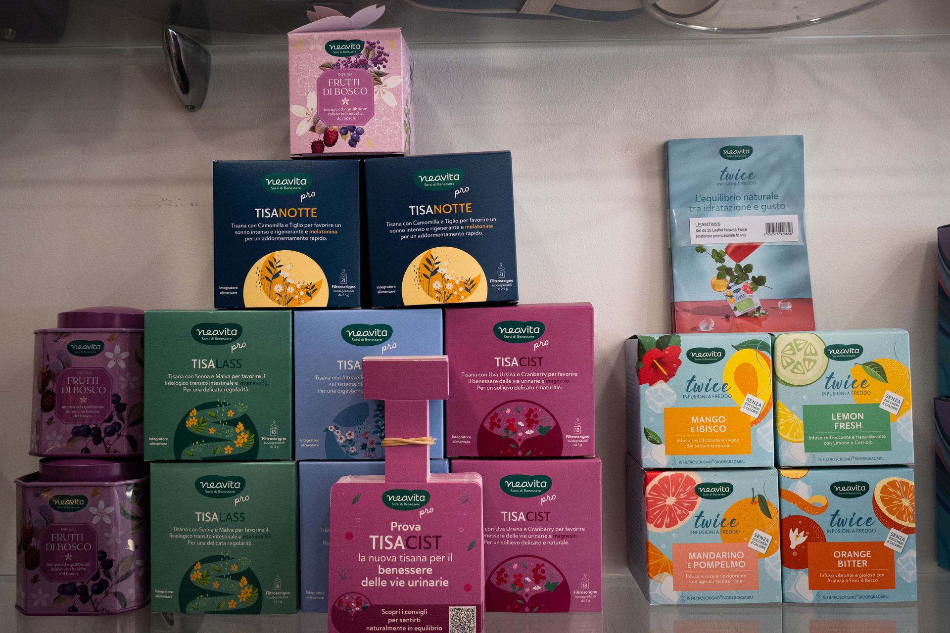 Esposizione su scaffale di varie scatole e lattine da tè in diversi colori.