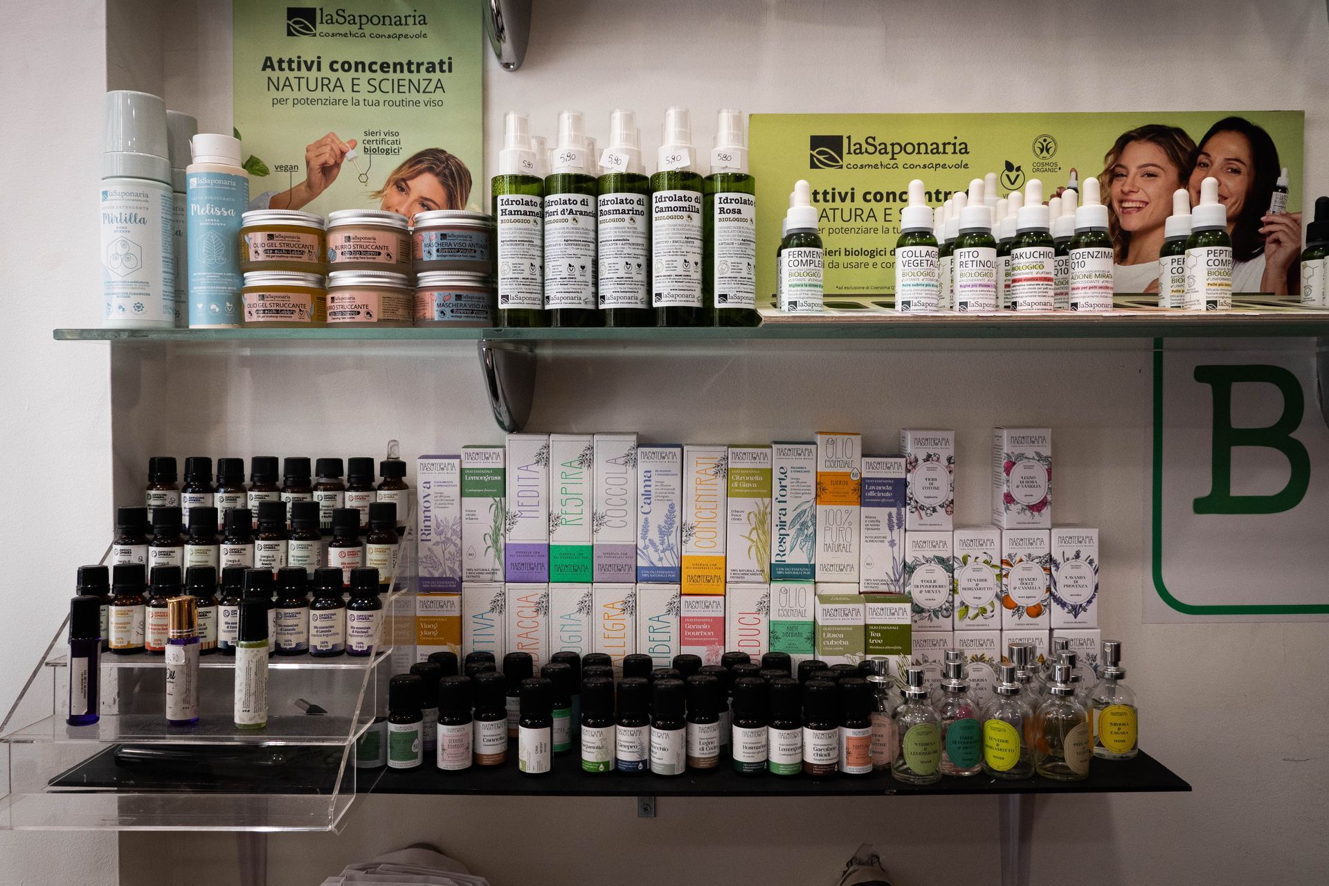 Scaffali pieni di prodotti per la cura della pelle, tra cui flaconi, barattoli e spray, esposti in un ambiente da negozio.