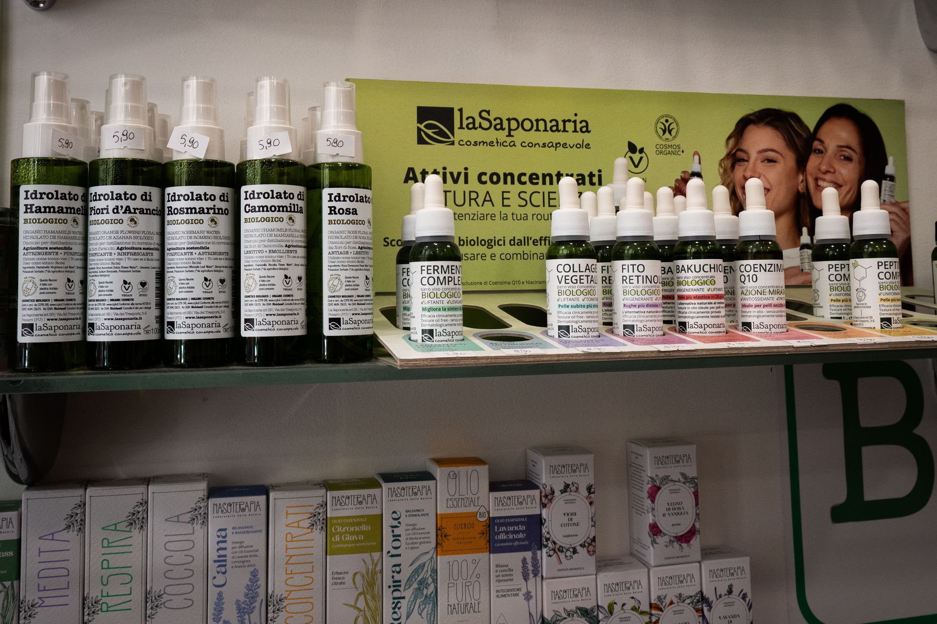 Scaffali che espongono prodotti farmaceutici, tra cui flaconi spray e contagocce, con un tema verde e bianco.