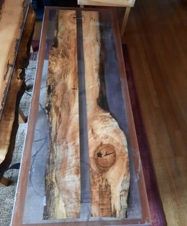 Wood and resin table with two wooden planks encased in clear resin.