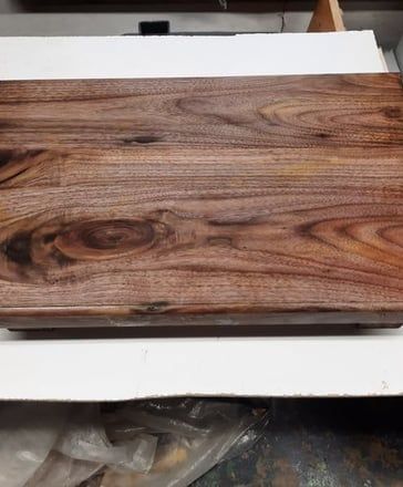 Wooden cutting board with rich brown grain.